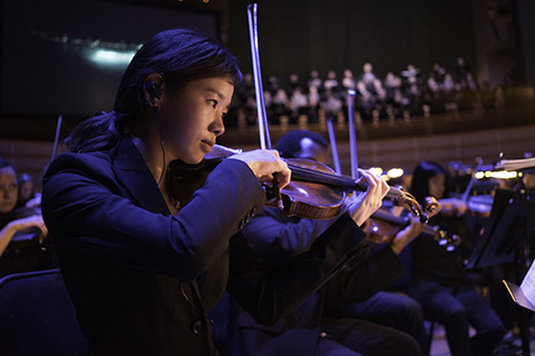 Frost School's Henry Mancini Orchestra student playing the violin during a performance